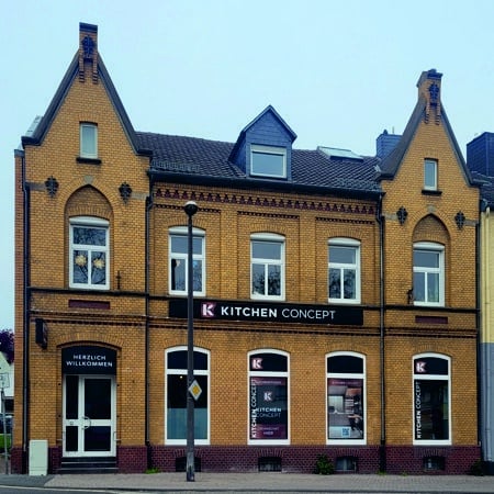 Ein altes ockerfarbenes Backsteingebäude ist der Firmensitz von Kitchen Concept Küche in Rheinbach.
