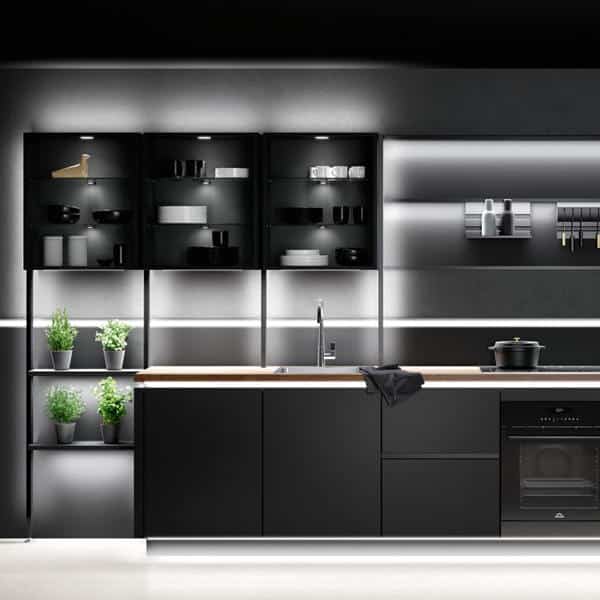 Eine schwarze Einbauküche mit schöner Beleuchtung.